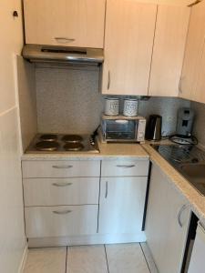 a kitchen with white cabinets and a stove top oven at Studio Mare Nostrum in Blankenberge