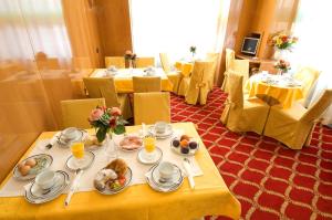 a dining room with tables and chairs with food on them at Hotel Cinque Giornate in Milan