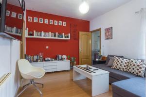 a living room with a couch and a red wall at Apartamento Urgel in Madrid