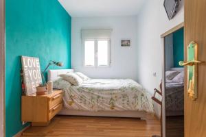 mała sypialnia z łóżkiem i oknem w obiekcie Apartamento Urgel w Madrycie
