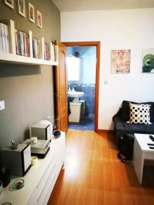 salon z kanapą i kuchenką mikrofalową w obiekcie Apartamento Urgel w Madrycie