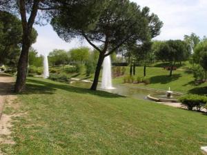a park with two water fountains in the grass at Apartamento Urgel in Madrid