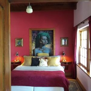a bedroom with a king sized bed with a painting on the wall at Fleur Bleue & The Timber Frame in Heidelberg