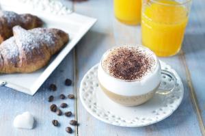 una taza de café en un plato junto a un plato de donuts en Nice Rome Holiday, en Roma
