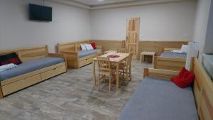 Schlafsaal mit Betten, einem Tisch und einem Tisch in der Unterkunft Apartmán Žamberk in Žamberk