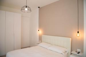 1 Schlafzimmer mit einem weißen Bett und 2 Leuchten in der Unterkunft Appartamento 150 in Rom