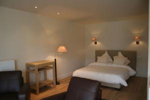 a bedroom with a bed and a table and chairs at De Groote Waere in Diksmuide