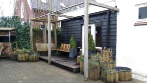 a patio with a bench and a pergola at Koeienstal, Private House with wifi and free parking for 1 car in Weesp