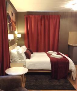 a hotel room with a bed and a red curtain at Bede Apartments in Coventry