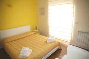 カリアリにあるDomus Yenne Suitesの黄色い壁のベッドルームのベッド1台