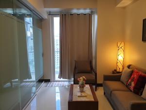 a living room with a couch and a table and a window at One Pacific Residence Condominium Tower C-16N in Mactan