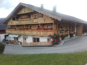 a large wooden house with flowers in front of it at Scherntreinerhof in Westendorf