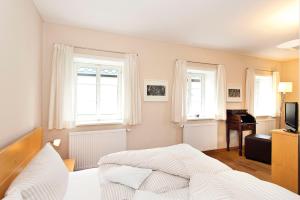 a bedroom with a bed and two windows and a piano at Fährmannhaus in Bad Schandau