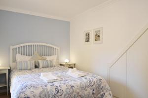 a bedroom with a bed with a blue and white comforter at Santana 2 - Checkinhome in Lisbon