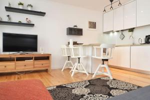 a living room with a tv and a kitchen at Santana 2 - Checkinhome in Lisbon