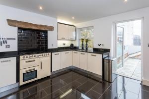 a kitchen with white cabinets and a black tile floor at The Penthouse Sale in Sale