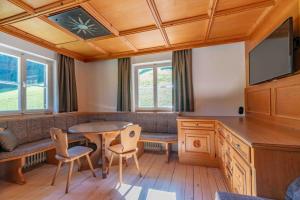 a living room with a table and chairs and a tv at Getznerhof in Westendorf