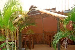 カトゥナーヤカにあるホテル シロンの木製のテーブルと椅子、看板のあるレストラン