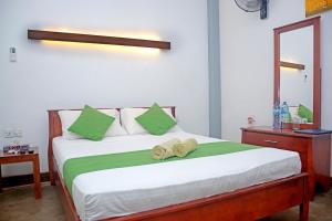 a bedroom with a bed with two towels on it at Hotel Thilon in Katunayake