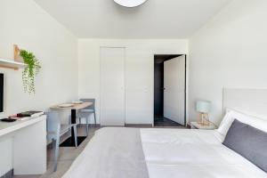 biała sypialnia z łóżkiem i stołem w obiekcie Student Factory Nice w Nicei