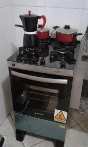 una stufa con due pentole e padelle sopra di LA DORITA a Búzios