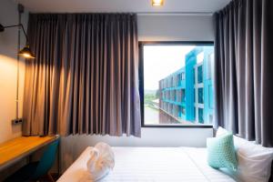 ein Schlafzimmer mit einem Bett und einem großen Fenster in der Unterkunft S.22 Hotel Suratthani in Surat Thani