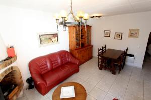 エンプリアブラバにあるLEON INMO Chalet Bianca - 10105のリビングルーム(赤い革張りのソファ、テーブル付)