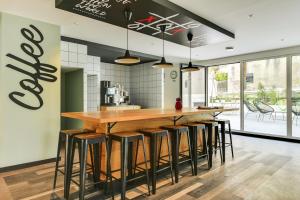 una cucina con un grande bar in legno con sgabelli di Student Factory Nice a Nizza