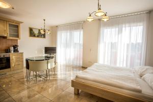 a bedroom with a bed and a table and a kitchen at Luxury Apartment Hotel Siófok in Siófok