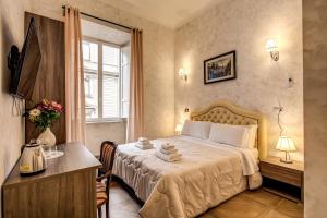 a bedroom with a bed and a table and a window at AMICI GUESTHOUSE in Rome