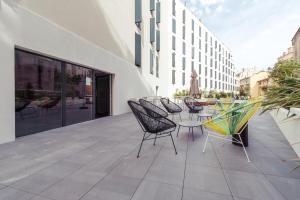 un patio avec des chaises et des tables dans un bâtiment dans l'établissement Student Factory Nice, à Nice