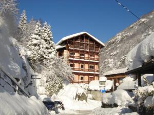 un edificio coperto di neve di fronte a un edificio di Albergo Dei Pescatori a Piode