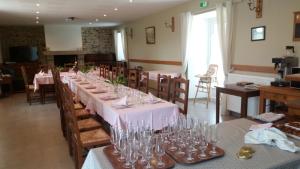 een eetkamer met een lange tafel met glazen erop bij Le Tertre in La Feuillie