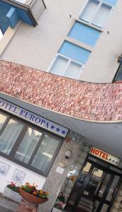 un edificio de hotel con un letrero que lee la madriguera del hotel en Hotel Europa en Albissola Marina