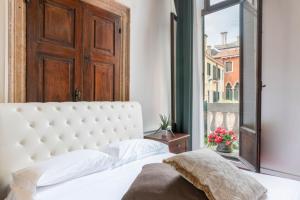 a bedroom with a white bed and a window at Venice Luxury Apartments in Venice