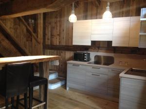 a kitchen with wooden walls and a table and a counter at Hotel Chateau Blanc in La Thuile