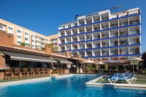 a hotel with a swimming pool in front of a building at htop Palm Beach & SPA #htopEnjoy in Lloret de Mar