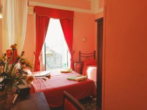 a red bedroom with two beds and a window at Villa Mabel in Taormina