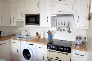 a kitchen with white cabinets and a stove top oven at Skene Terrace Apartments in Aberdeen +10 photos