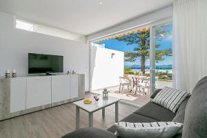 sala de estar con sofá, TV y mesa en Apartment CB 2 en Alcúdia