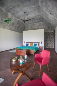 um quarto com uma cama, uma mesa e uma cadeira em Elakai em Munnar