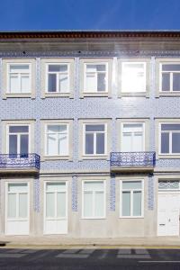 ポルトにあるCasa da Joanaの青と白のタイルが施された窓のある建物