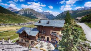 an aerial view of a house with mountains in the background at Residence Baita Cusini in Livigno