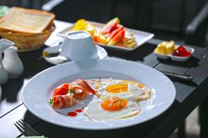 a plate of food with eggs and fruit on a table at The Branch B&B in Negombo