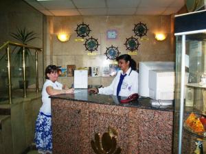 Dos mujeres de pie en un mostrador en un restaurante en Orchida St. George Hotel en Asuán