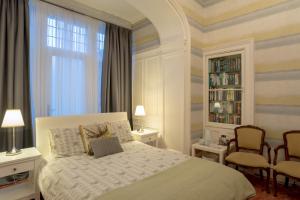 a bedroom with a bed with two chairs and a book shelf at Kingsley Guest House in Edinburgh