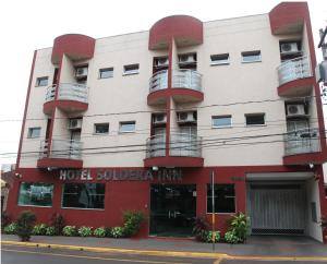 a building with two balconies and a hotel solitude inn at Hotel Soldera Inn in Sertãozinho