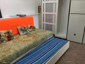 a bed with an orange headboard in a room at Su da noi in San Dorligo della Valle