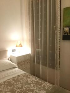 a bedroom with a bed and a window with a lamp at LOFT "Residenza dei TOLOMEI" - Sacile in Sacile