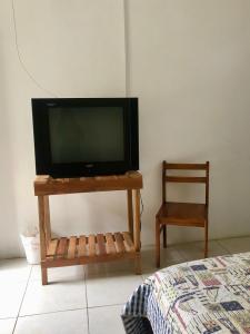 un televisor sentado en una mesa junto a una silla en Hotel Santorini, en Cojimíes